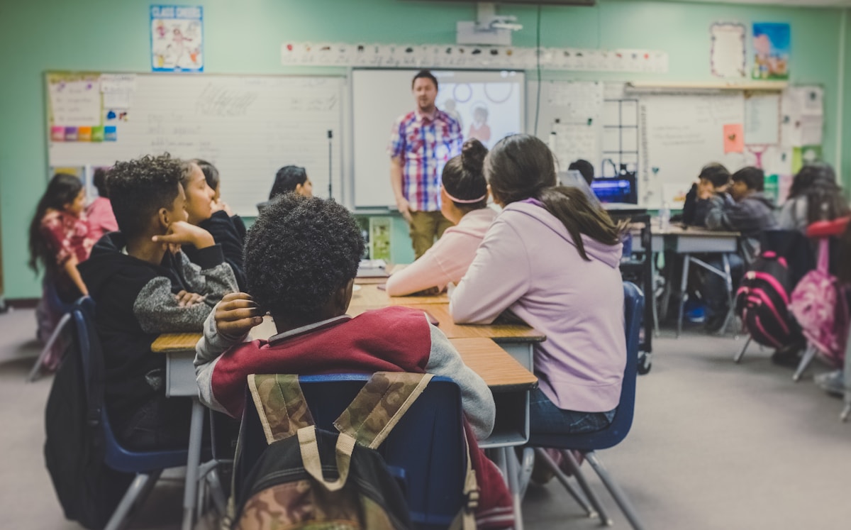 Professor a ensinar alunos numa sala de aula multicultural